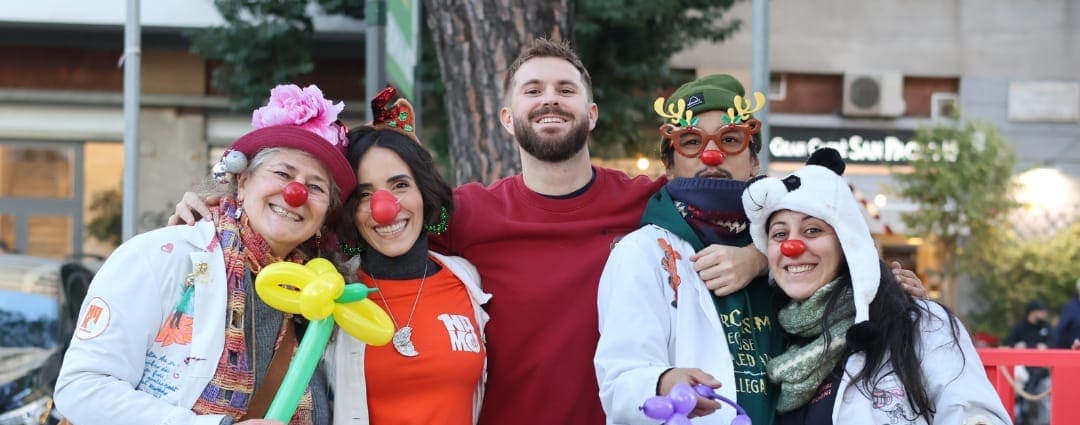 Volontari di Namo APS con il naso rosso e i palloncini a un banchetto di raccolta fondi